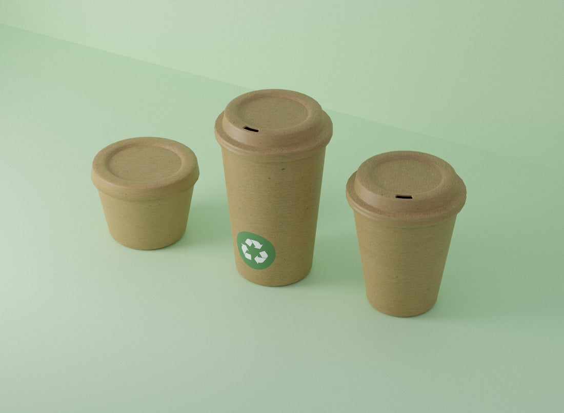 Three recyclable cups sit on a light green surface.